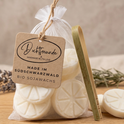 Weißes Organzasäckchen gefüllt mit handgefertigten Zitronenscheiben aus Bio-Sojawachs mit Citronella-Duft, inklusive Holzzange und Dochtfreunde-Etikett.