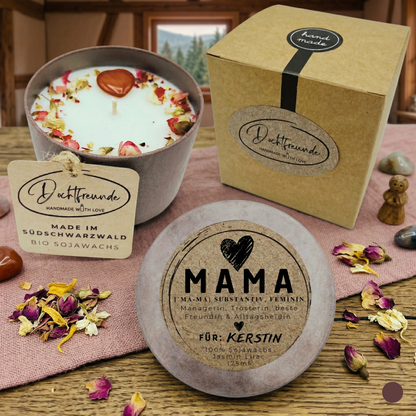 Eine personalisierte Bio-Sojawachs-Kerze im Betongefäß für Mama, handgefertigt im Schwarzwald. Zu sehen ist die Kerze mit Trockenblumen und Edelstein-Herz, die passende Kraftpapier-Geschenkbox und ein personalisierter Deckel mit der Aufschrift „MAMA Definition“ und dem Wunschnamen „Kerstin“.