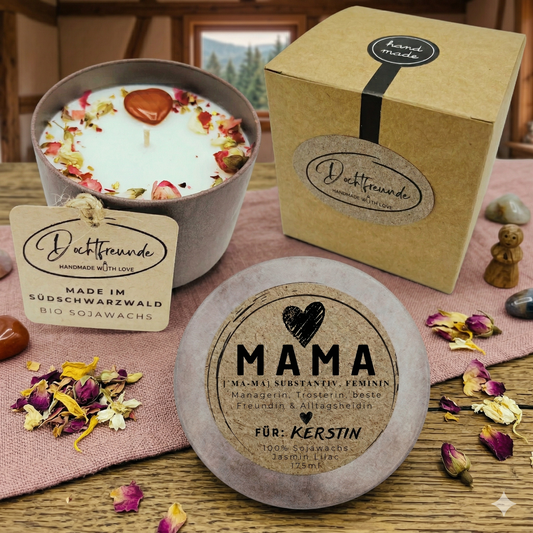 Eine personalisierte Bio-Sojawachs-Kerze im Betongefäß für Mama, handgefertigt im Schwarzwald. Zu sehen ist die Kerze mit Trockenblumen und Edelstein-Herz, die passende Kraftpapier-Geschenkbox und ein personalisierter Deckel mit der Aufschrift „MAMA Definition“ und dem Wunschnamen „Kerstin“.